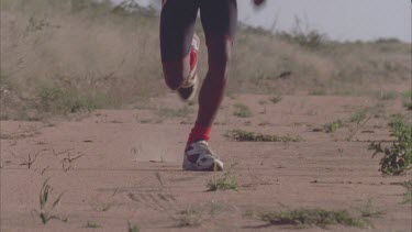 African man running towards camera in slow motion dry arid background