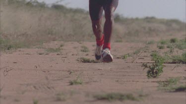 Feet of African man running towards camera