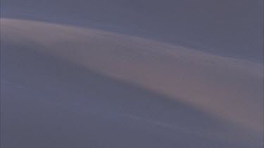 wind blowing sand down sand dune