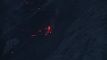 Red hot lava rock falling down the side of Komba volcano