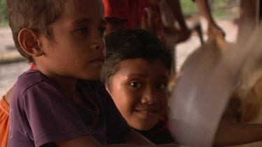 Children watching as a native Sampan canoe is carved