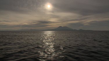 Sunlit island seen from a speeding tender