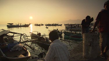 Boats moored in a fishing village at dusk