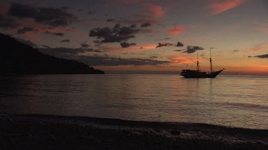 Seven Seas ship anchored in a bay at sunset