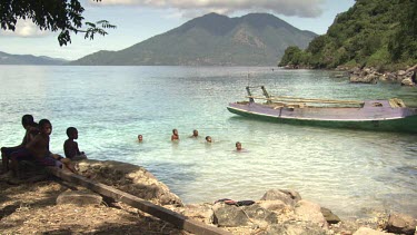 Village children playing in harbour water