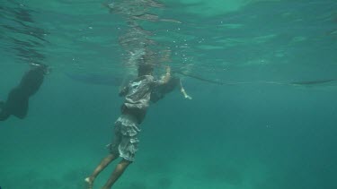 Snorkelers swimming with a Whale Shark at the ocean surface