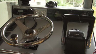 Close up of the steering wheel and throttle of a boat