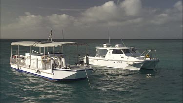 Pair of white boats anchored in the ocean