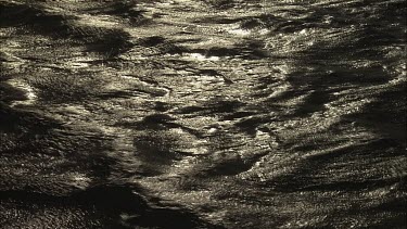 Close up of gentle waves on the sunlit ocean