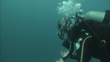 Diver swimming further down. Reaching the coral.