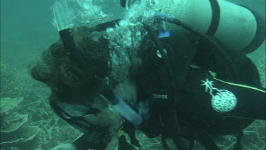 Diver holding worm in hands.