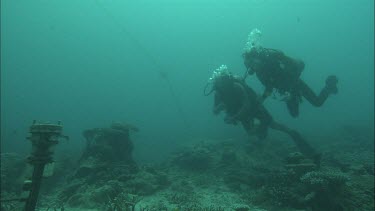 Diver signals other diver then checks the time