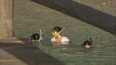 Three girls are snorkeling.