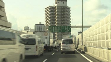 Traffic driving on a city highway by apartment complexes