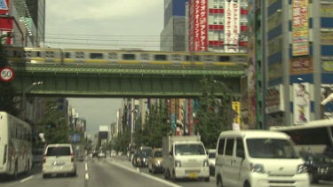 Train on tracks above street traffic in a busy city