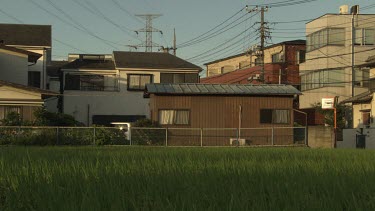 Cyclist riding by a beige house
