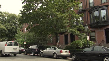 Traffic driving by an elegant brick apartment