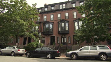 Cars parked in front of an elegant brick apartment