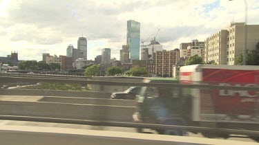 Driving on a bridge past a city