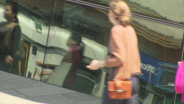 Pedestrians walking past a reflective surface