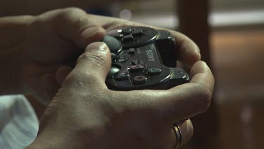 Close up of a person playing on a Playstation controller