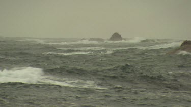 Rough waves breaking against rocks