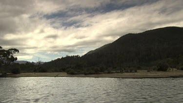 Trees and mountains along the edge of a river