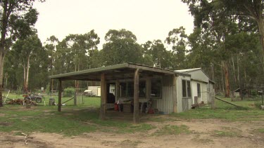 Farmer walking by a wooden farm building