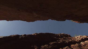 Blue sky seen from the narrow path between two high cliffs