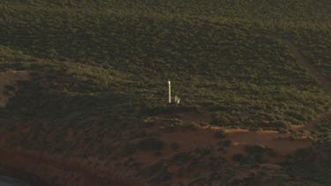 Distant lighthouse on the coast at sunrise