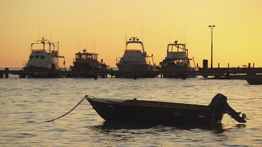 Silhouette of a boat moored off the coast at sunset