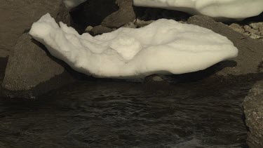 Patch of snow over a flowing stream