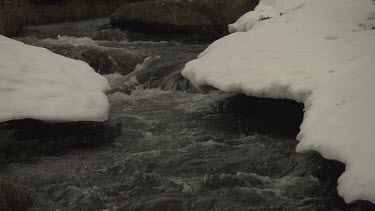 Snow banking a flowing stream