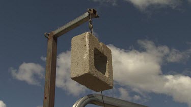 Cement cube hanging from a pulley
