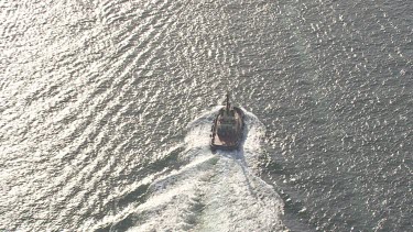 Boat travelling in the sunlit Sydney harbour