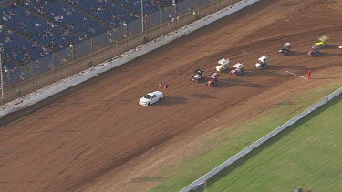 Car and colourful motor carts driving on a circular racetrack