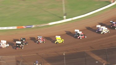 Car and colourful motor carts driving on a circular racetrack