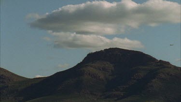 Light plane passing over mountain top