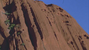 dramatic shadow cast across Uluru pan across texture small hair in gate at top