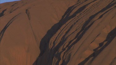 Uluru surface showing undulating rock and light and shade full frame rock