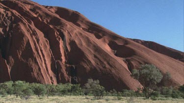 pan across Uluru surface some blue sky behind