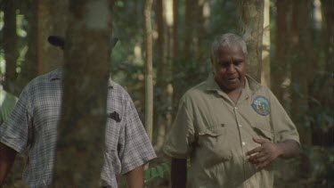 two rangers walk through forest under story indigenous aborigines