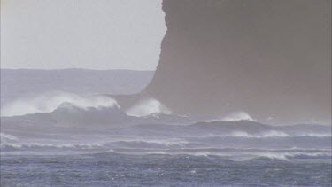 waves rolling in in front of rocks
