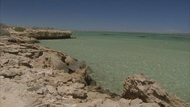 clear green water in bay pan from cliff out to the water