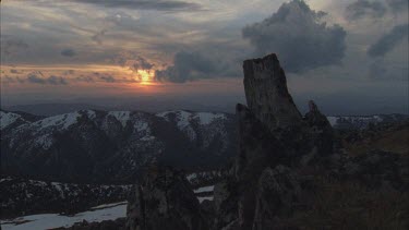 prominent or large boulder in foreground overlooking valley as sun comes up beautiful light