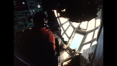 Pilot flying cargo plane interior shot, see through nose of plane.