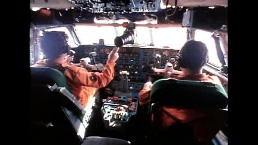 Pilot and co pilot flying cargo plane interior shot