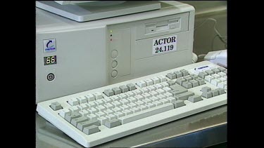 Scientist in chemical protection suit types on old computer