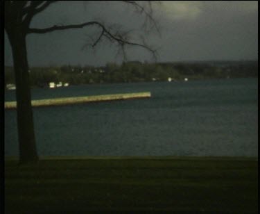 Bare and stark trees silhouetted against a lake