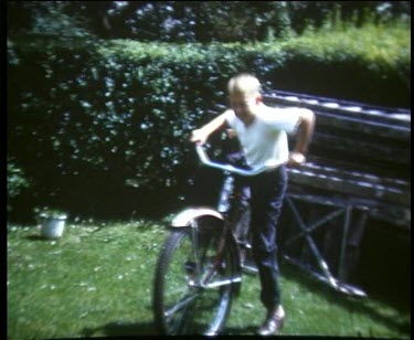 Child riding bicycle in front garden